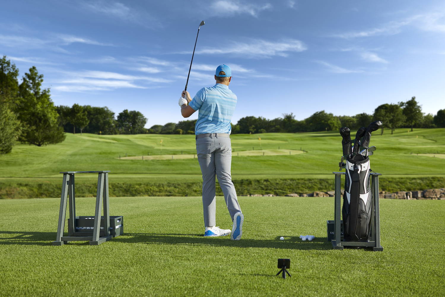 Golfer on the course with Garmin Approach R10 launch monitor and simulator