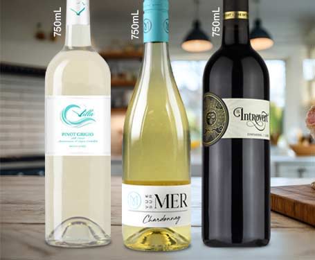 Three bottles of wine on a kitchen counter.