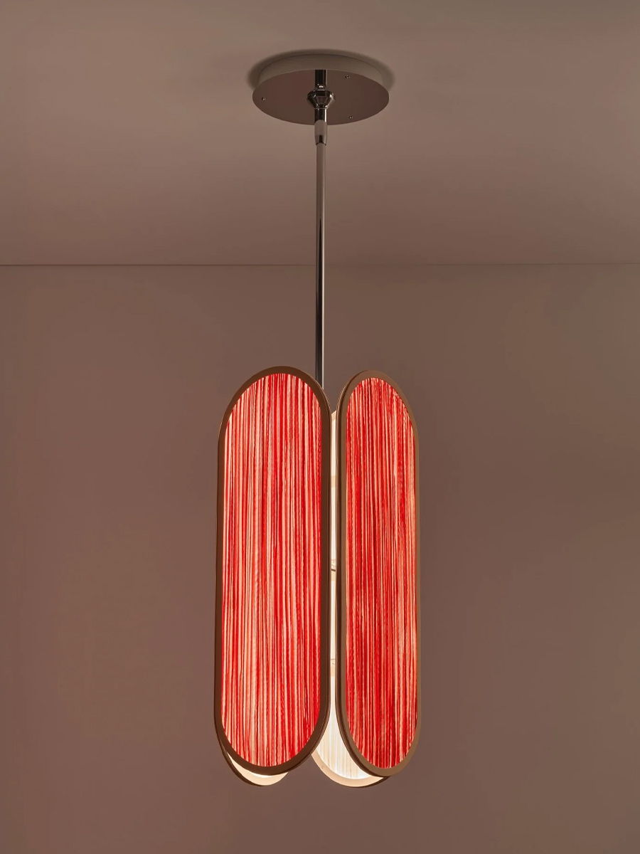 Modern pendant lamp with red, elongated shades hanging from a ceiling.