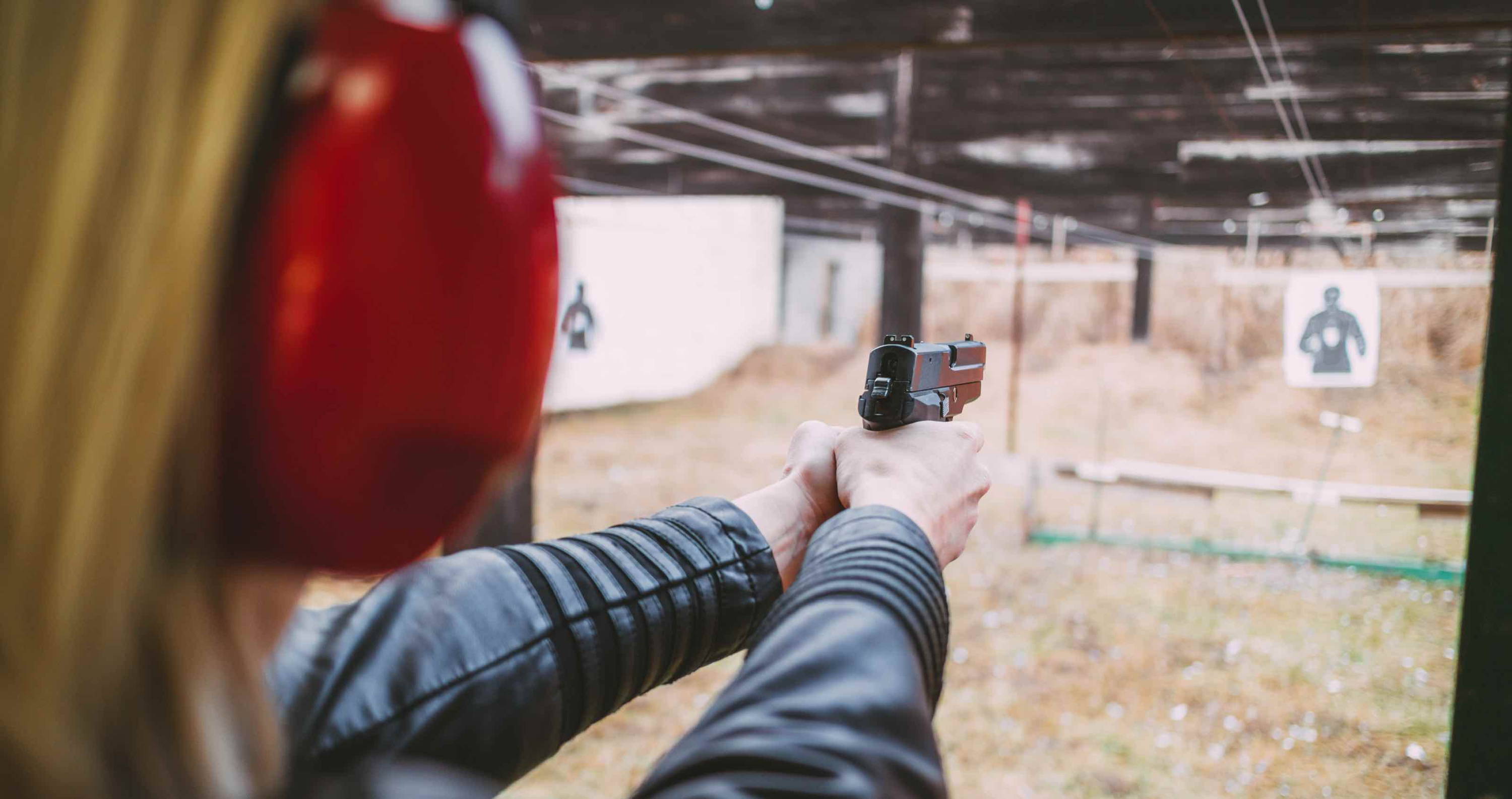 Woman shooting gun with ear protection