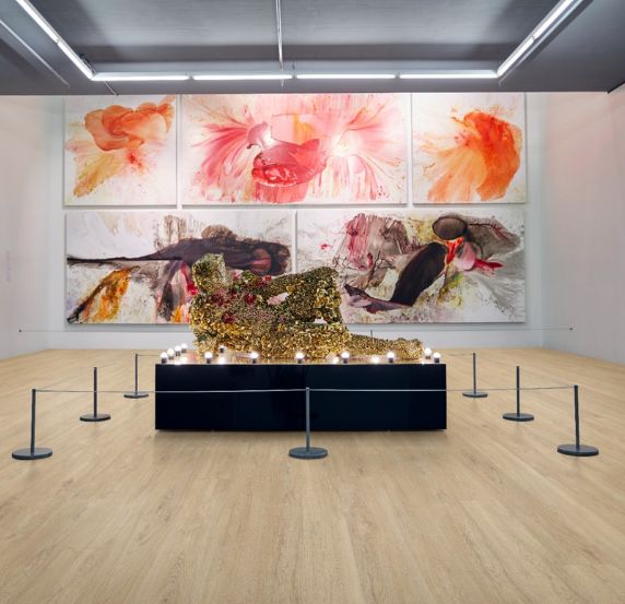 Luxury vinyl tiles in an art installation with colorful wall paintings and a central exhibit with text 