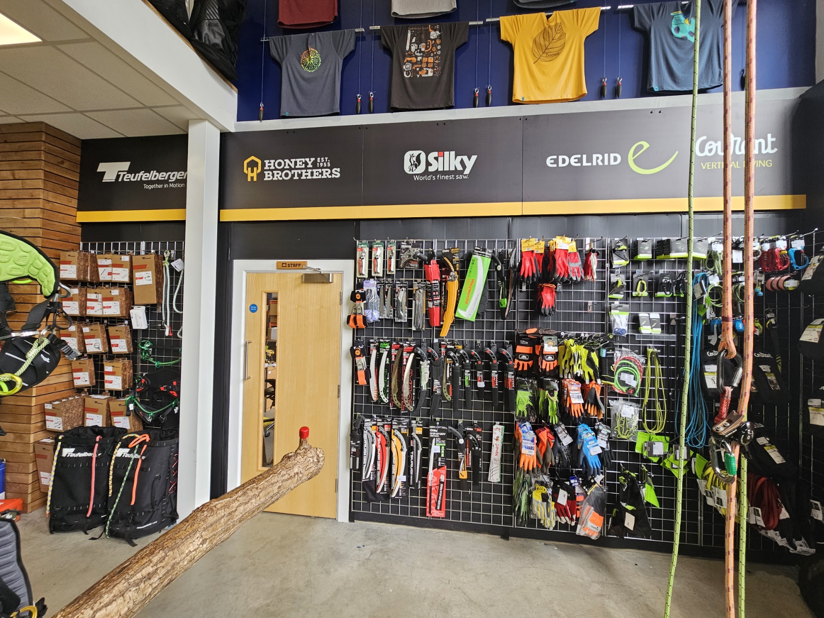 Interior of a store displaying climbing gear and apparel on walls.