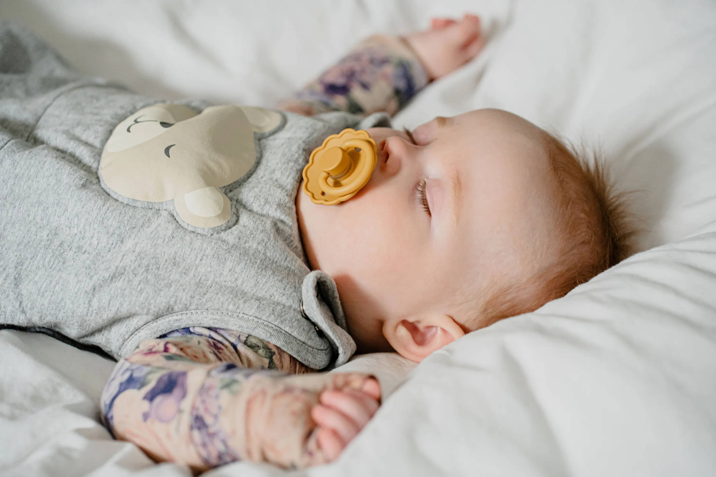 Baby der sover roligt med sin sovepose med tyngde