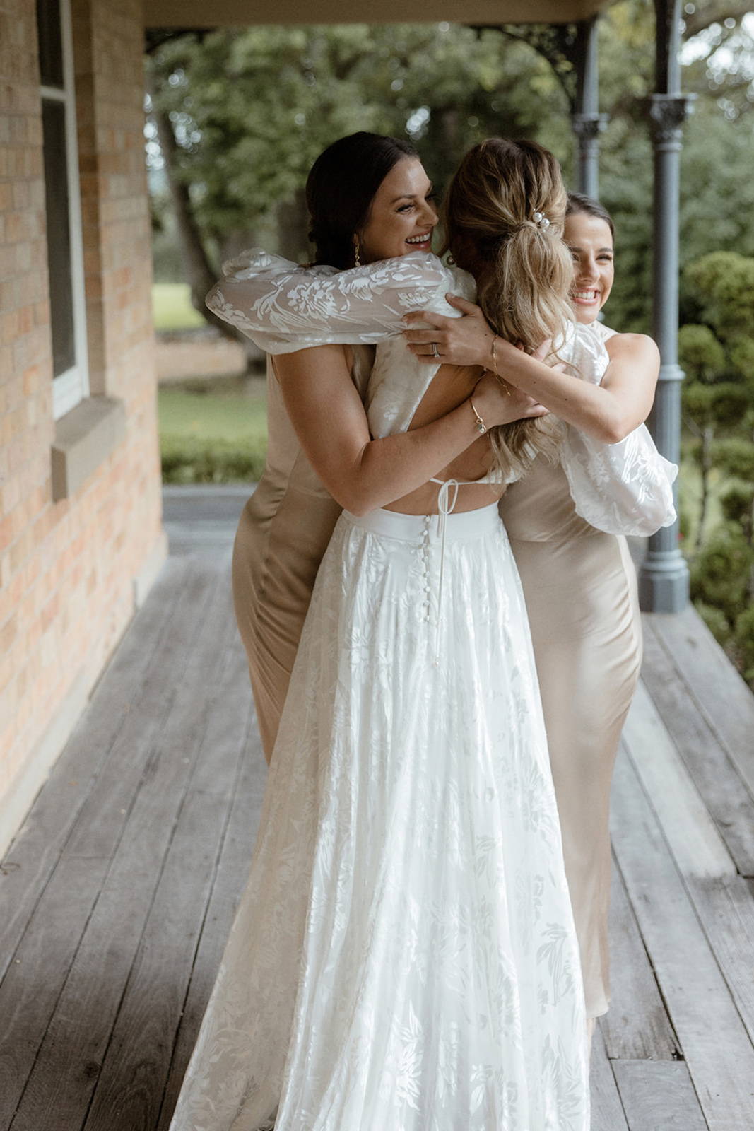 Bride hugging bridesmaids
