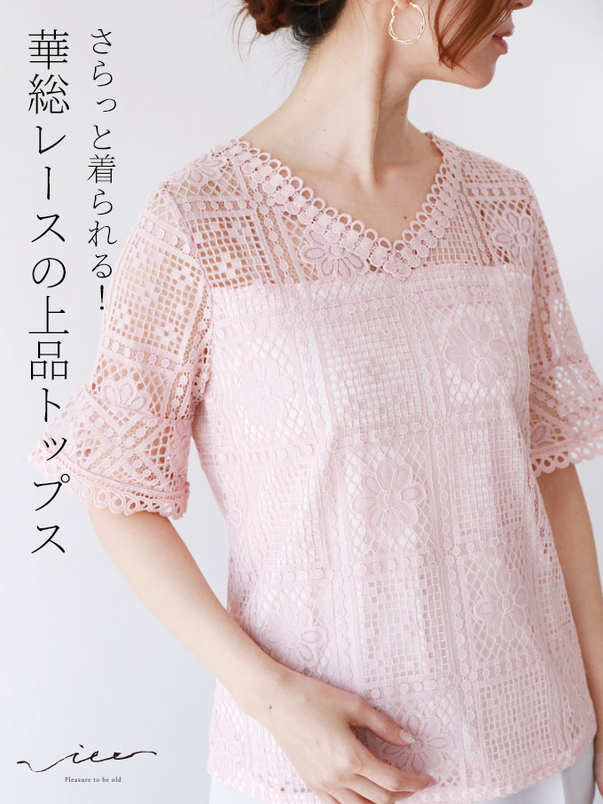 Woman wearing a pink lace top with short sleeves.