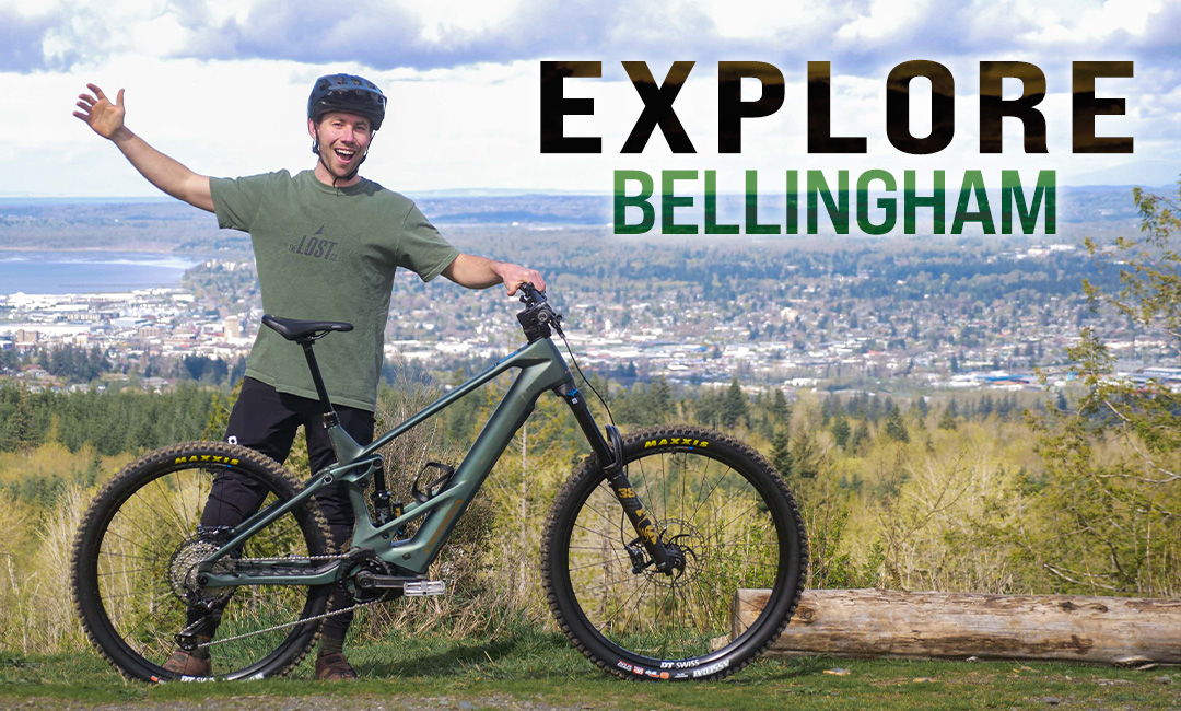 Person with a bike promoting exploration in Bellingham, scenic background.