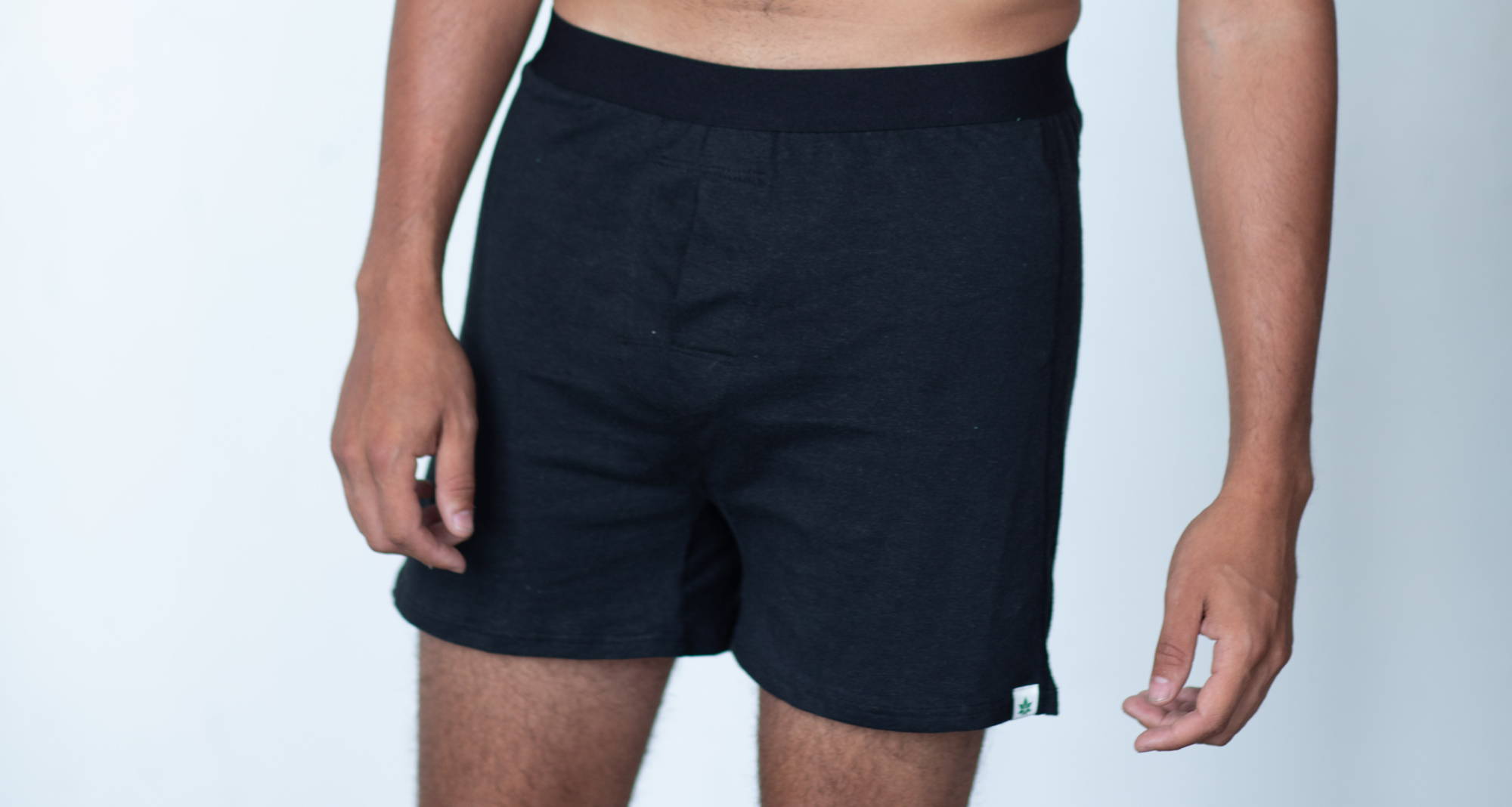 man wearing black boxers against a white background
