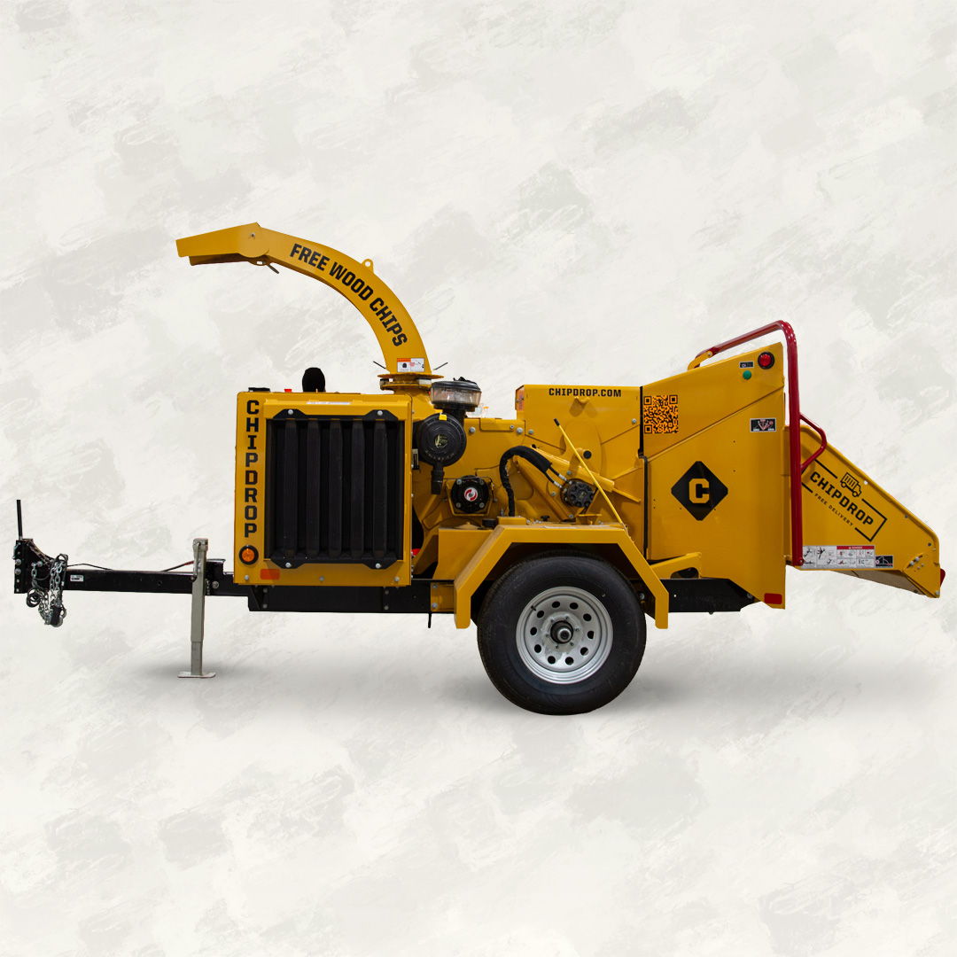 Yellow wood chipper machine with a trailer attachment.