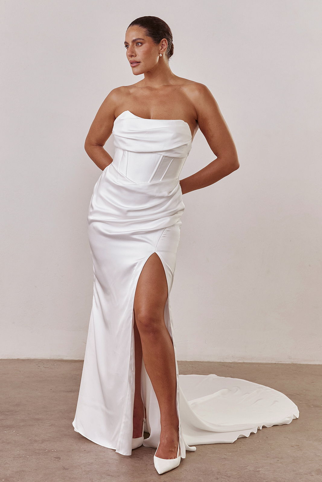A woman in a strapless white dress with a thigh-high slit.