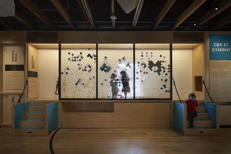 Children interacting with a colorful exhibit in a museum setting.