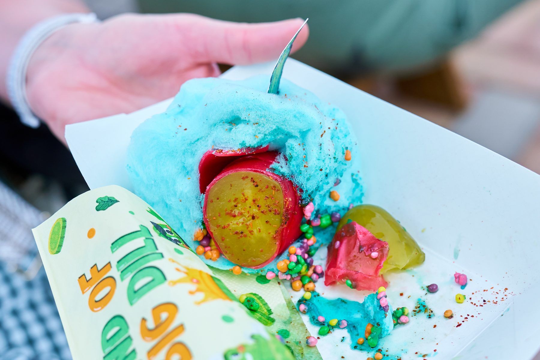 Chamoy-coated pickle wrapped in cotton candy with Nerds candy and Tajin seasoning at The Big Dill pickle festival.