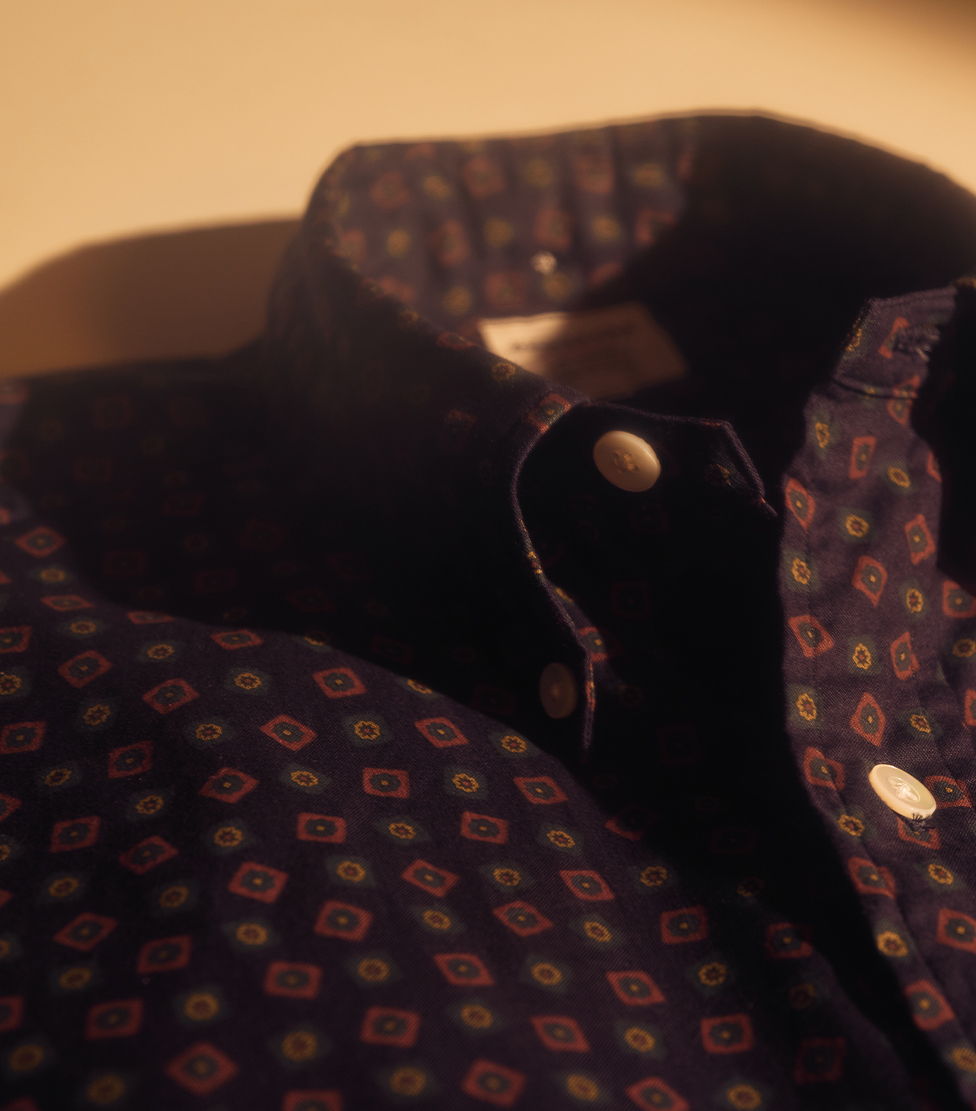 Close-up of a patterned shirt collar and buttons.
