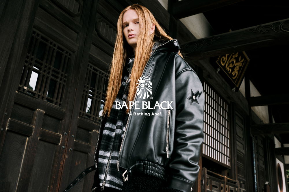 Model wearing a black leather jacket in an urban setting.