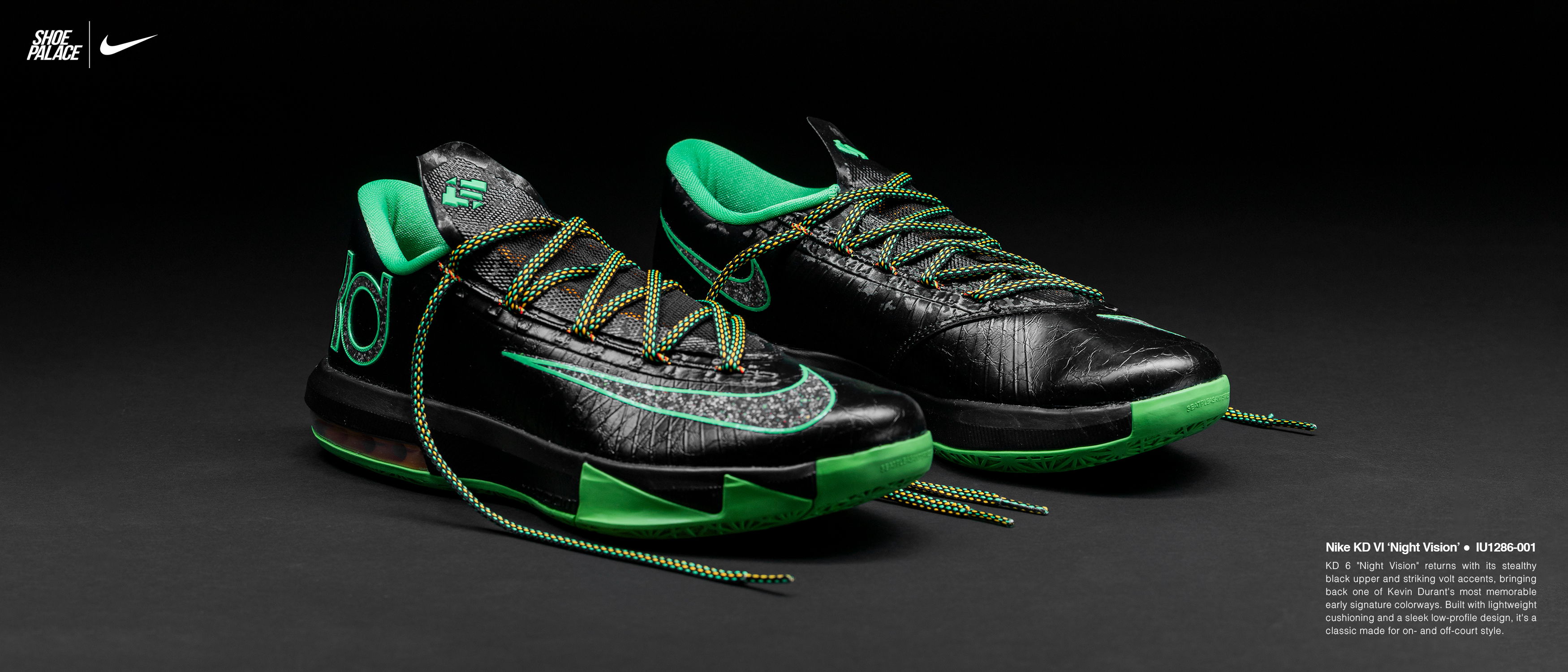 A pair of black and green athletic shoes on a dark background.