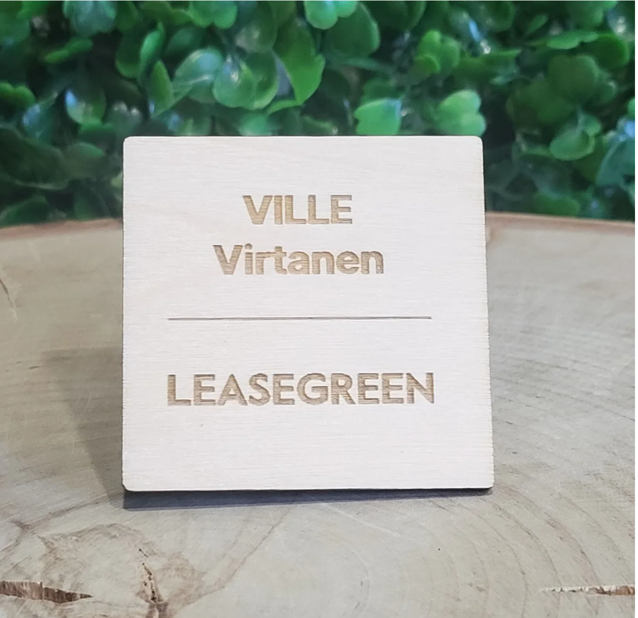 Suomessa valmistettu puinen nimikyltti yrityksen logolla ja työntekijän nimellä