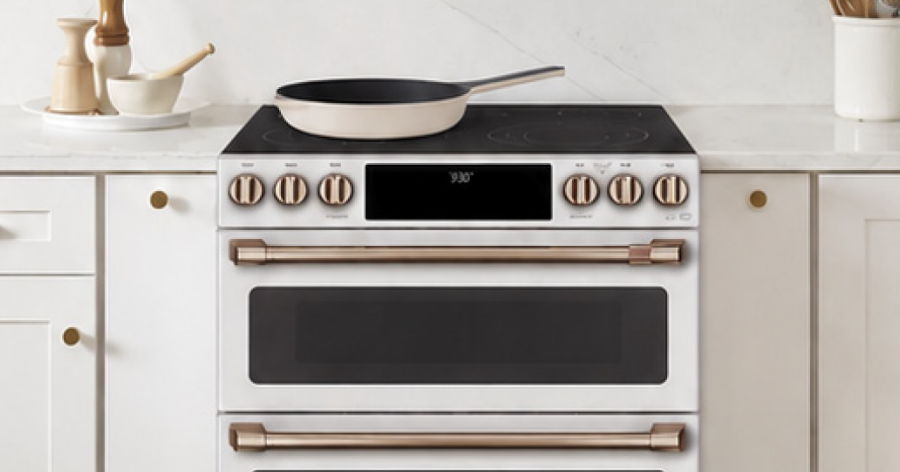 Modern kitchen stove with a frying pan on top.