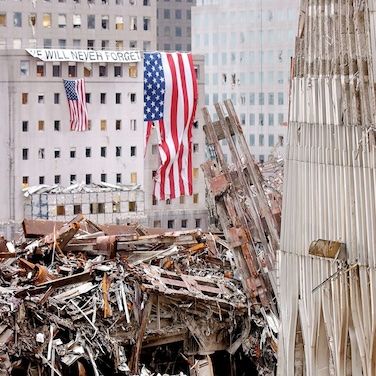 Destruction site with American flags in a cityscape aftermath.