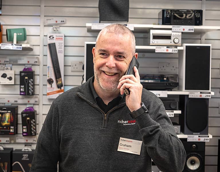 Store colleague smiling and talking on the phone in one of our stores.