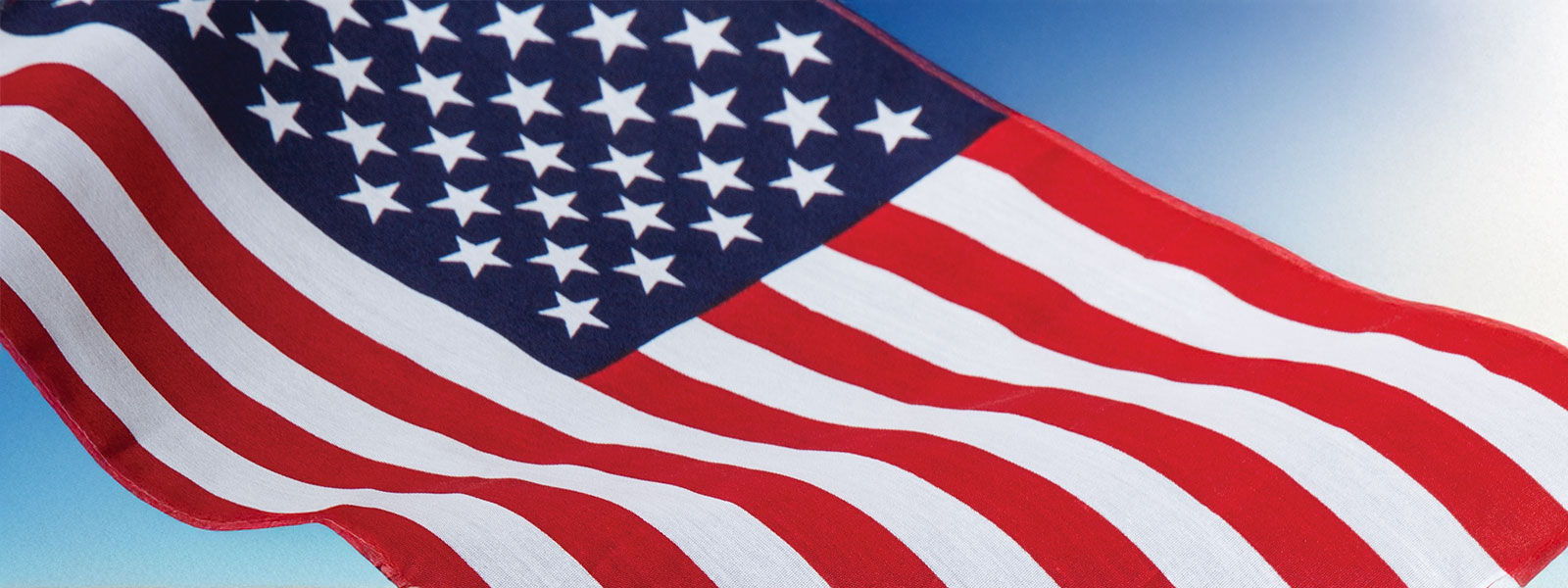 US Flag on blue sky background.