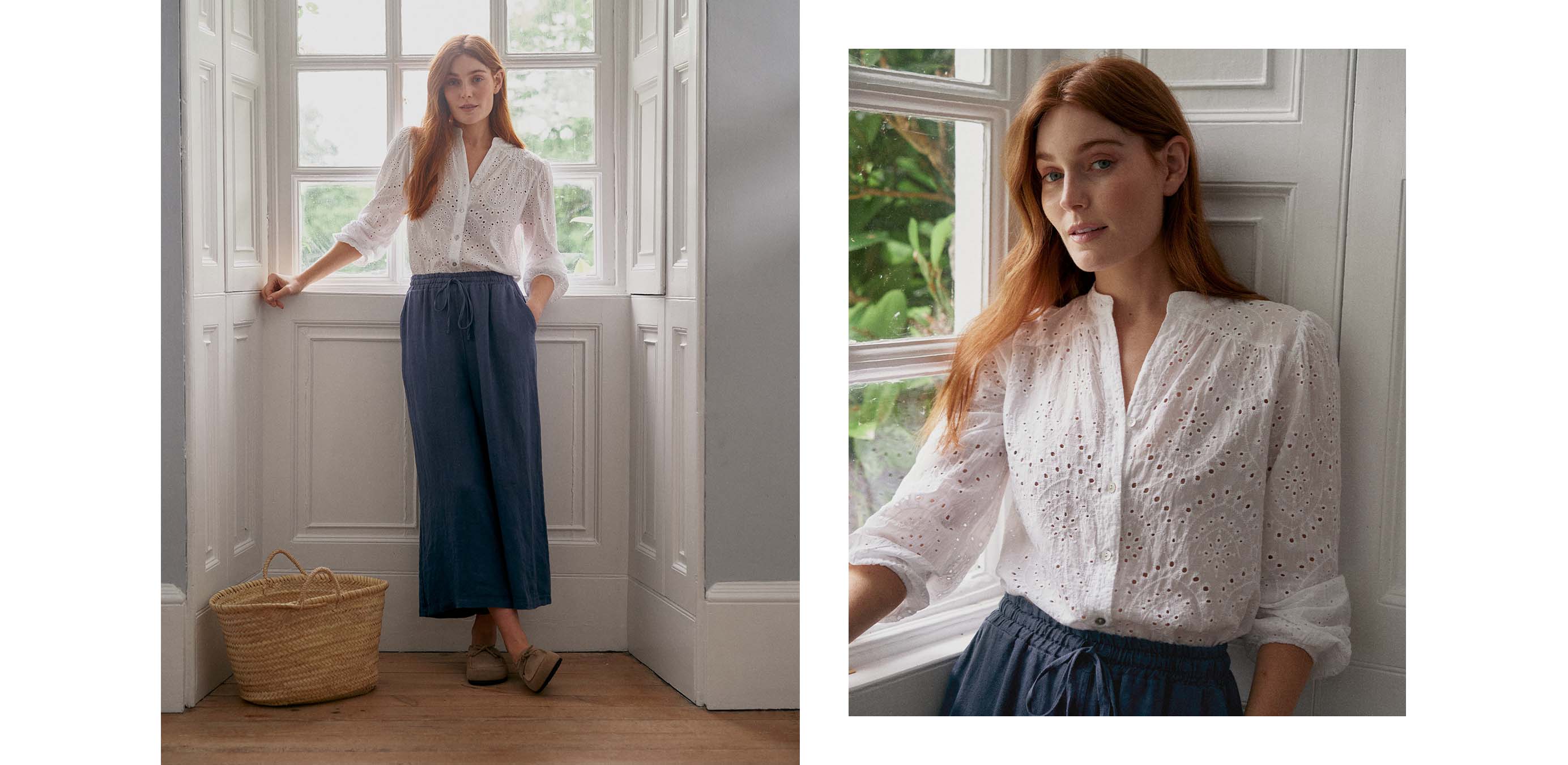 Woman standing in a window with a white broderie anglaise top and blue cropped trousers