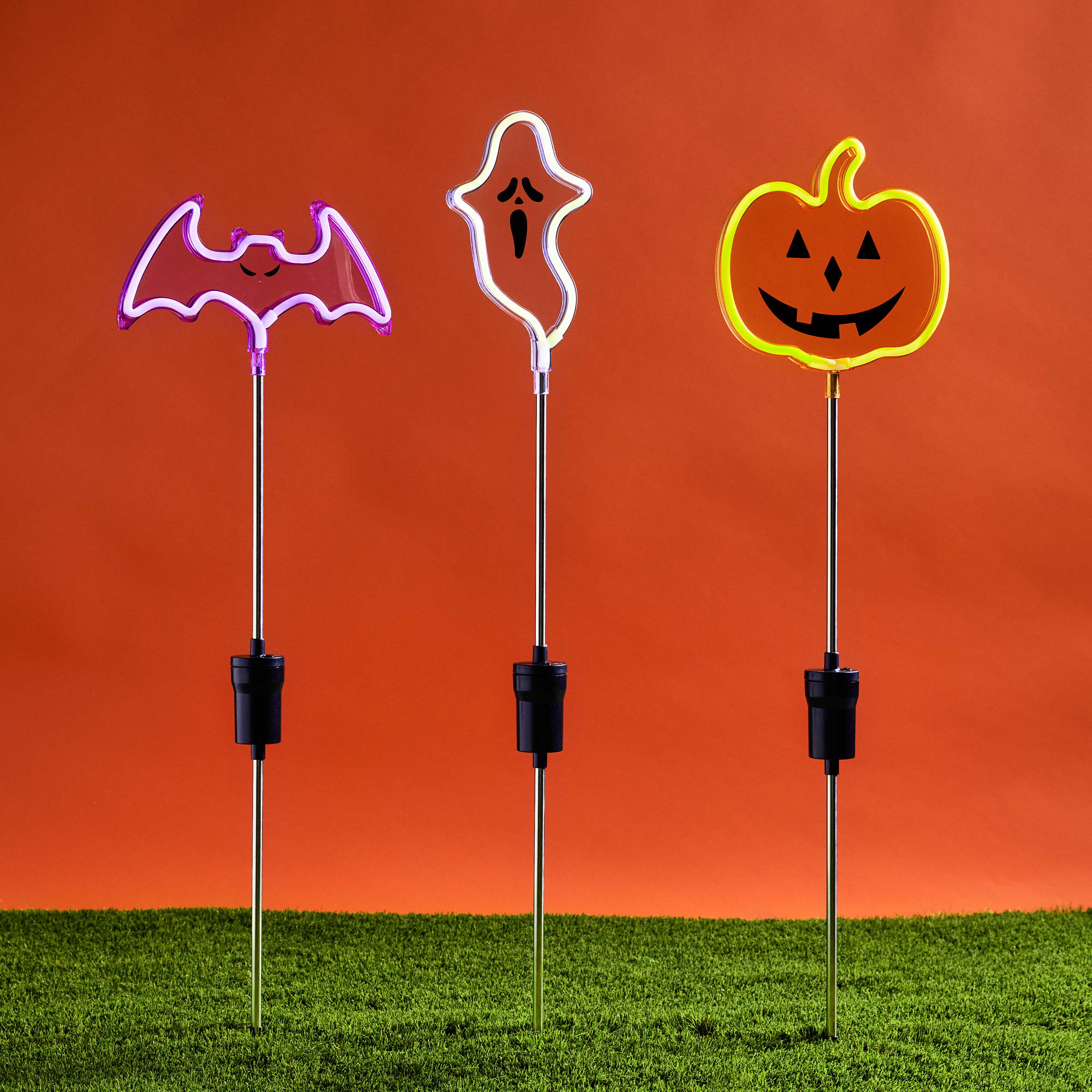 Drei Neon Halloween Stableuchten mit orangen Hintergrund