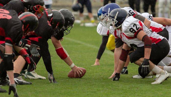 Two football teams playing football on field