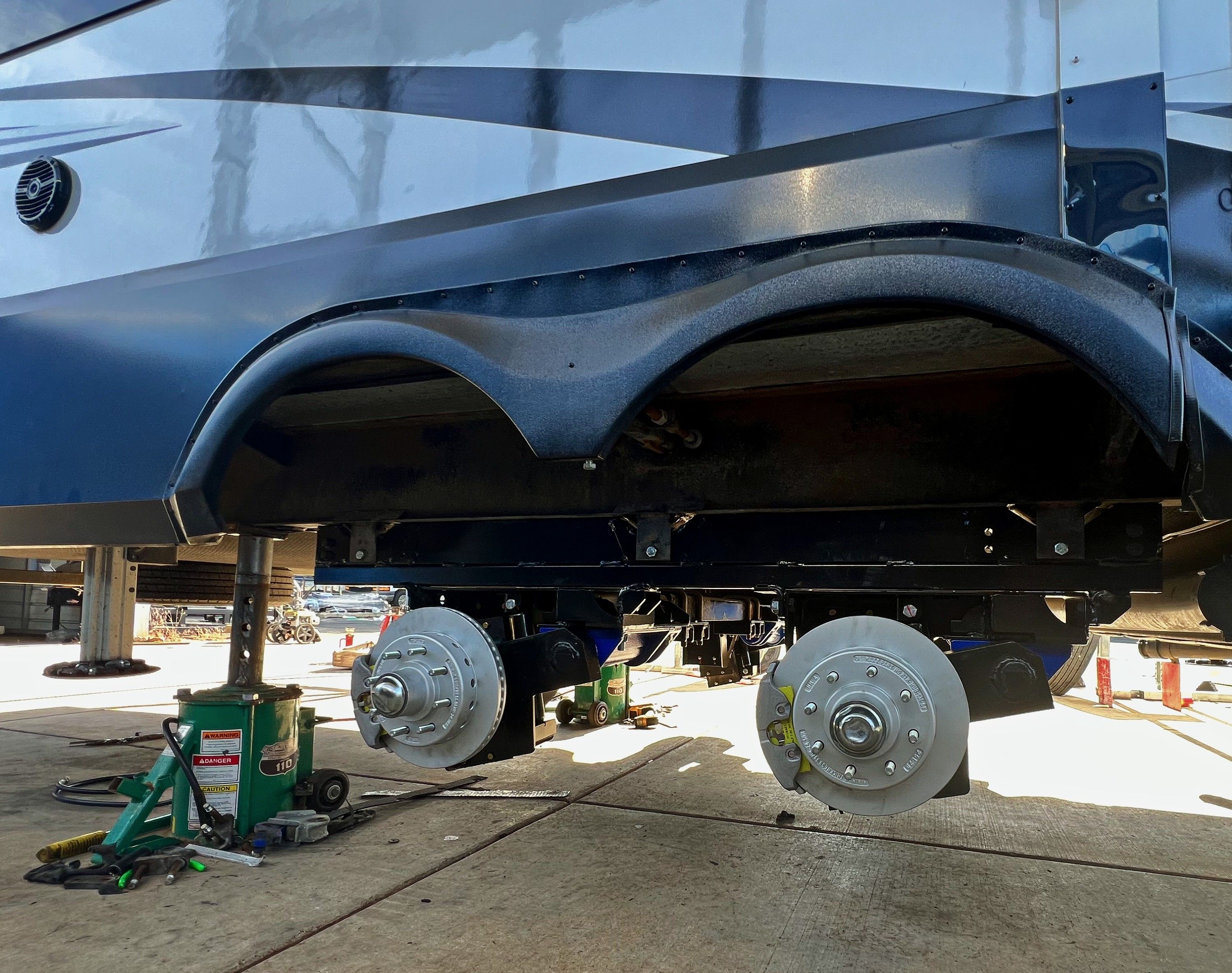 Close-up of a vehicle's undercarriage with visible wheels and supports.