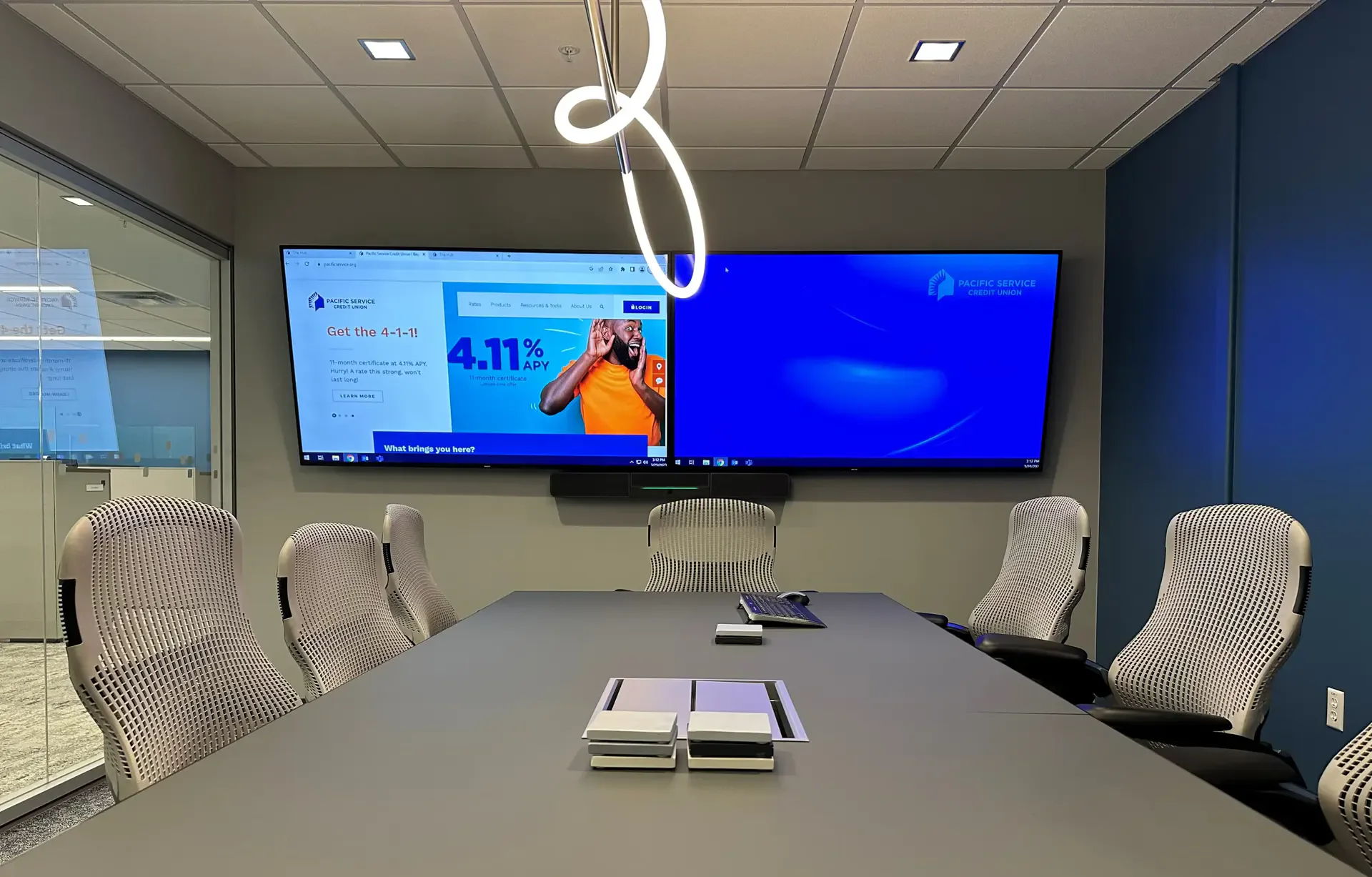 Conference room with two screens and modern seating.