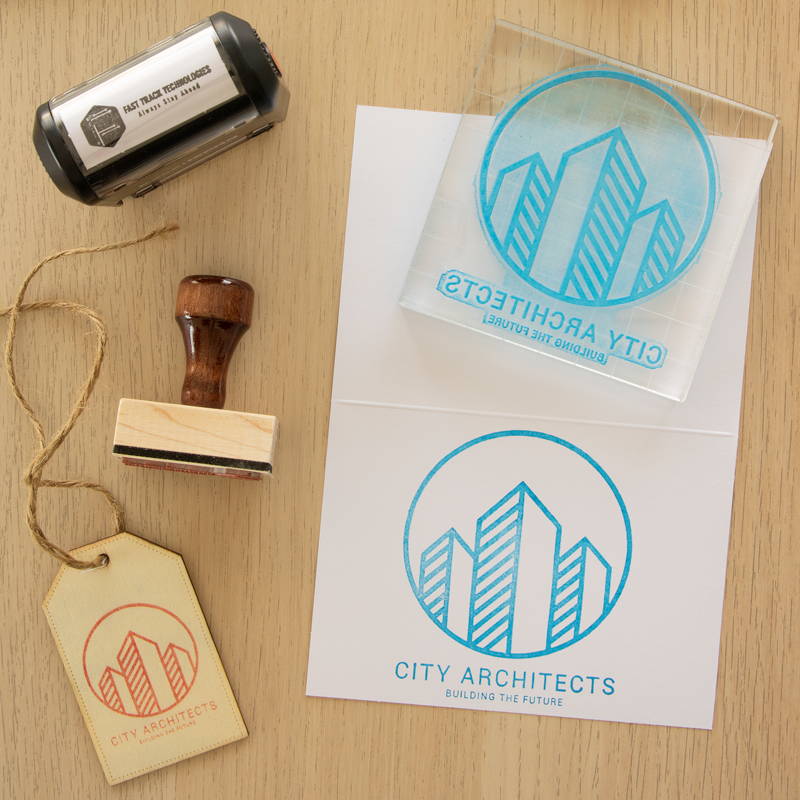 Logo stamp with a self inking and traditional stamp to the left. Two imprints are made on both a letter and product tag.