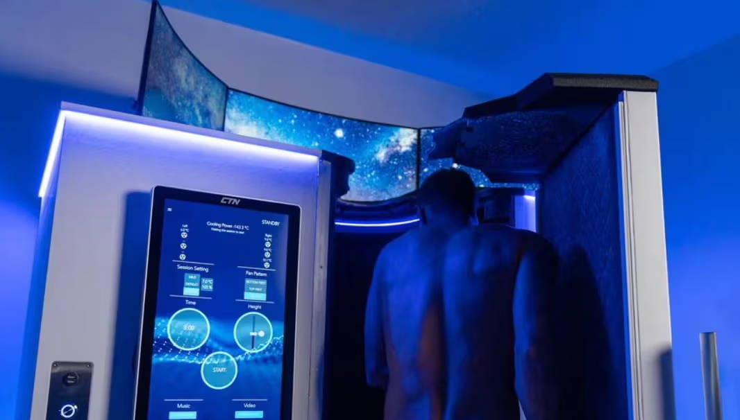 A male customer stepping into an electric whole body cryotherapy chamber known as the ECabin.