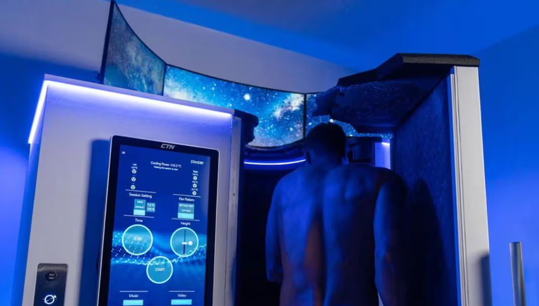 A male customer stepping into an electric whole body cryotherapy chamber known as the ECabin.
