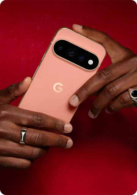 A person holding a pink smartphone with a camera on a red background.