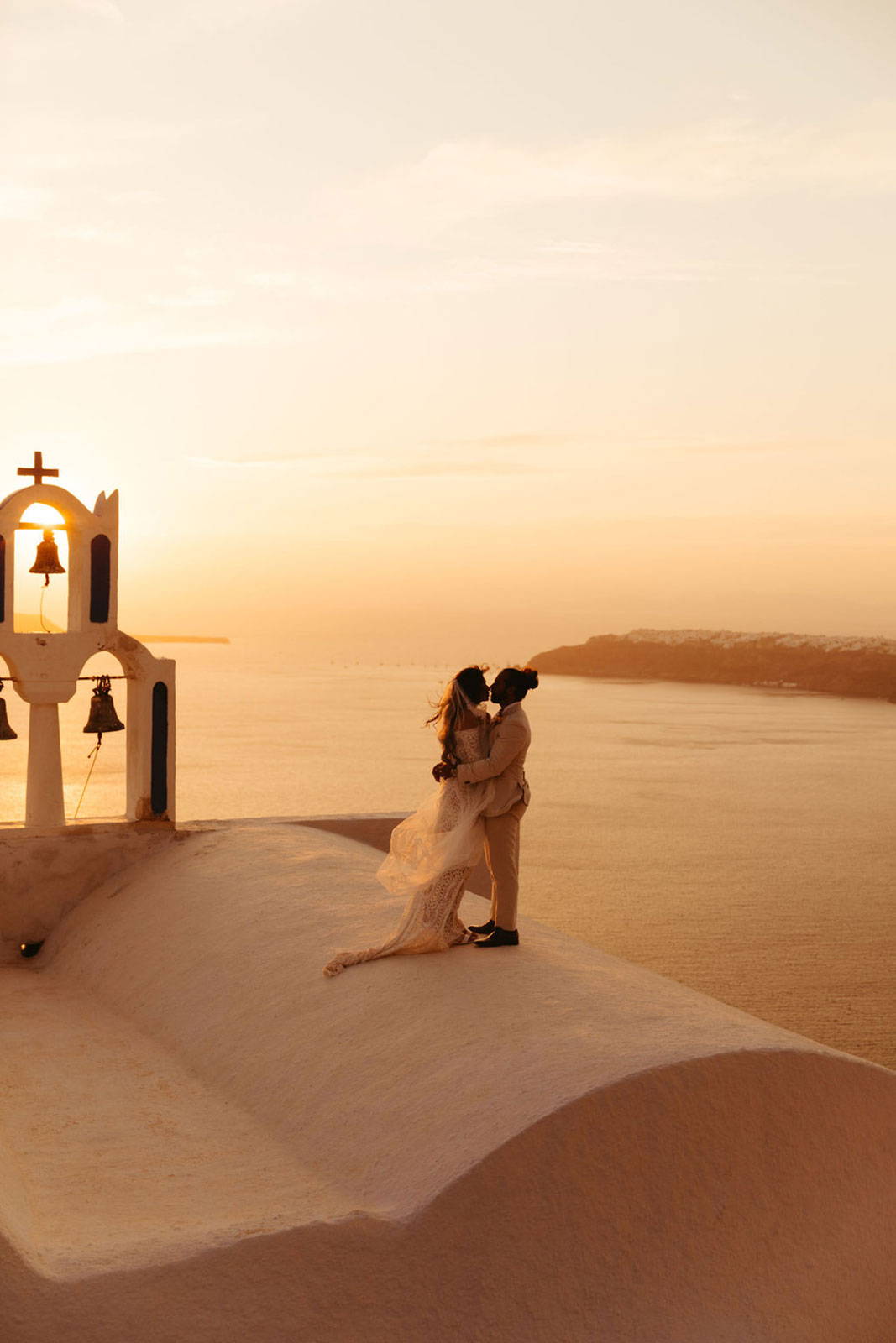 Les mariés partagent un baiser à Santorin.