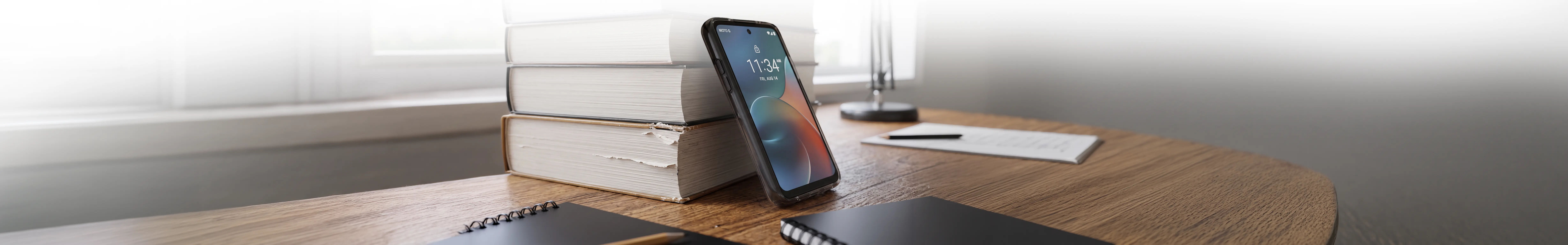 A budget smartphone chosen for a student resting on textbooks.