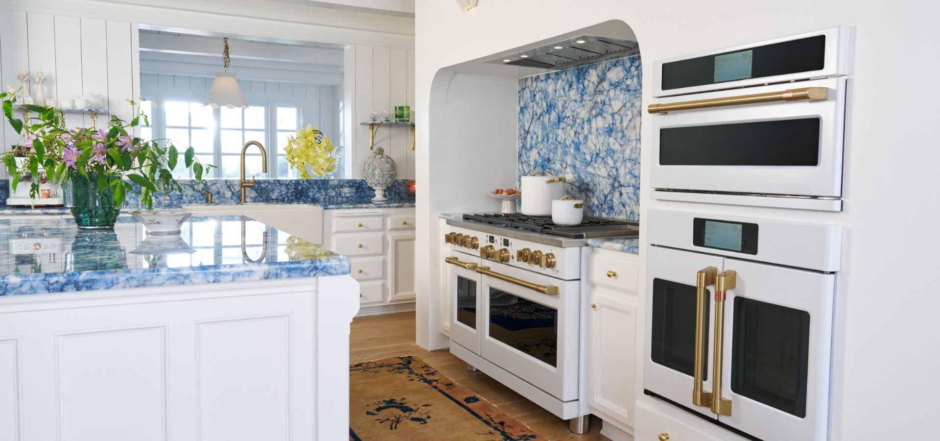Kate Hudson's kitchen with white cabinets, blue backsplash, and matte white appliances.