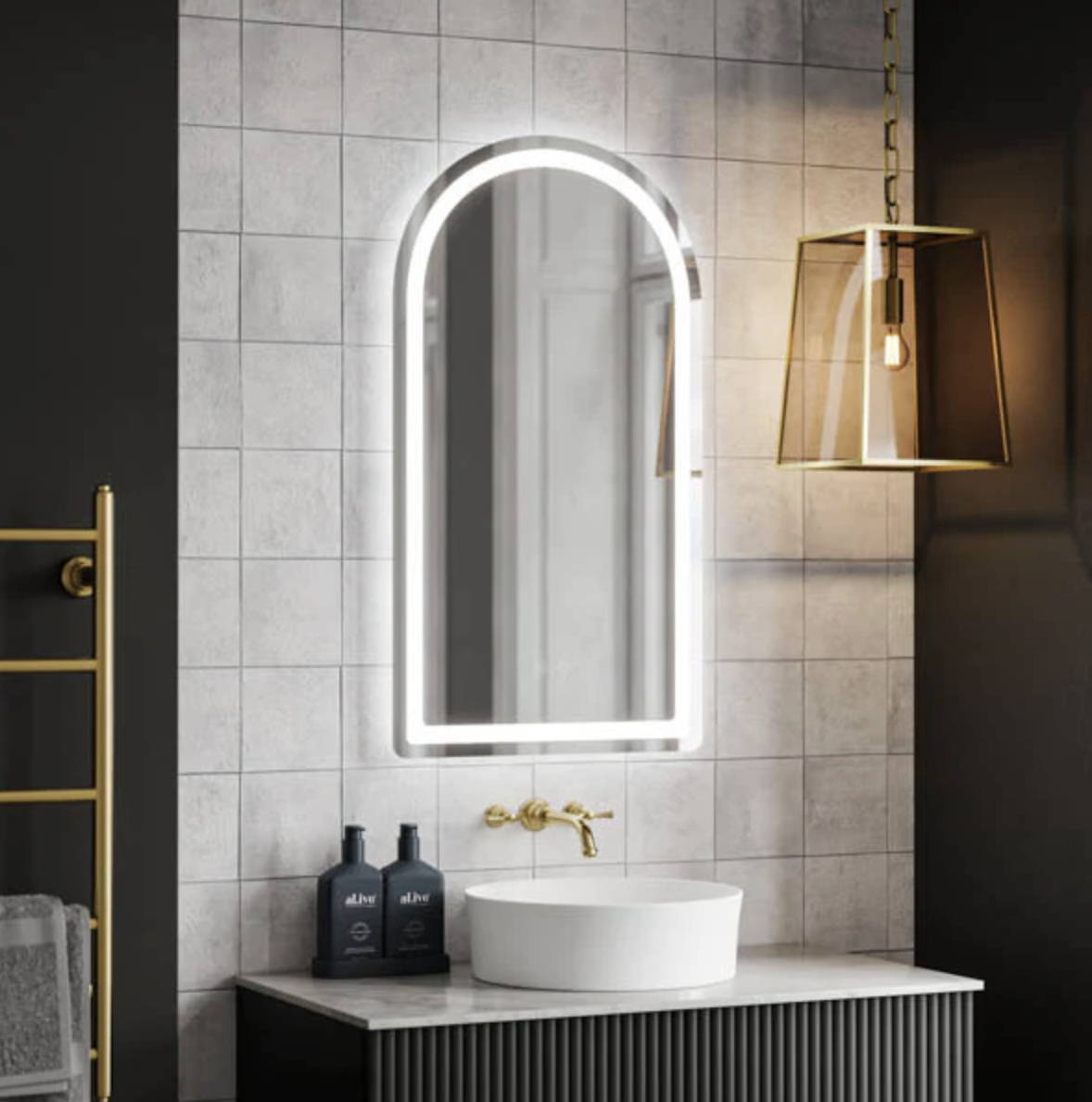 Moody bathroom with gold fixtures and LED mirror