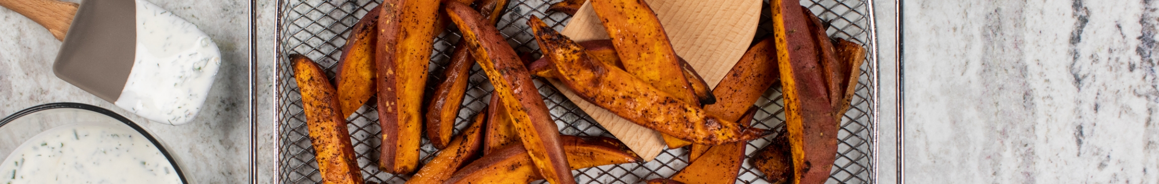Air fried sweet potato strips on a textured surface.