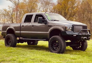 Brian's lifted charcoal grey 2005 Ford F250 Super Duty with winch bumper parked on a grassy field