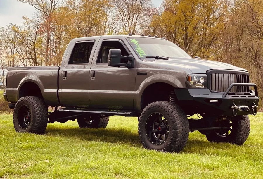 Brian's lifted charcoal grey 2005 Ford F250 Super Duty with winch bumper parked on a grassy field