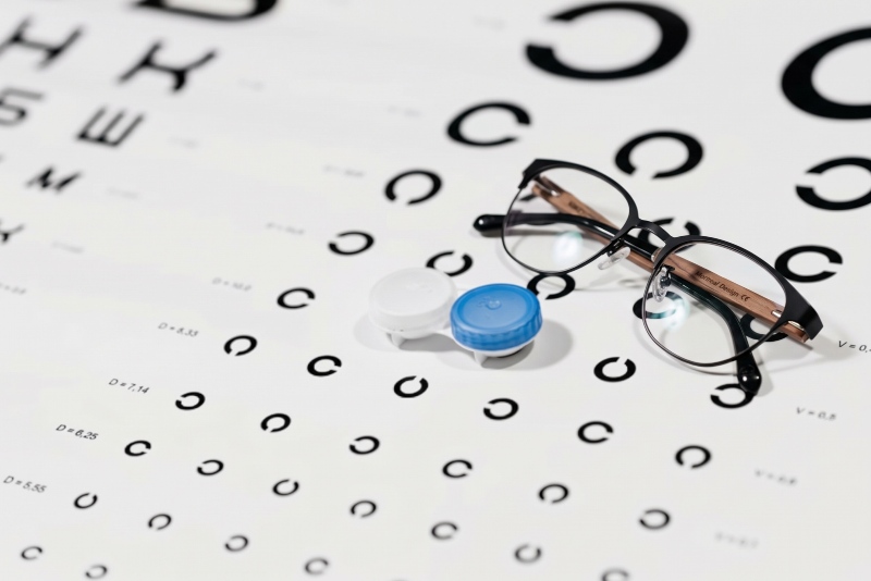 contacts and glasses on eye exam chart
