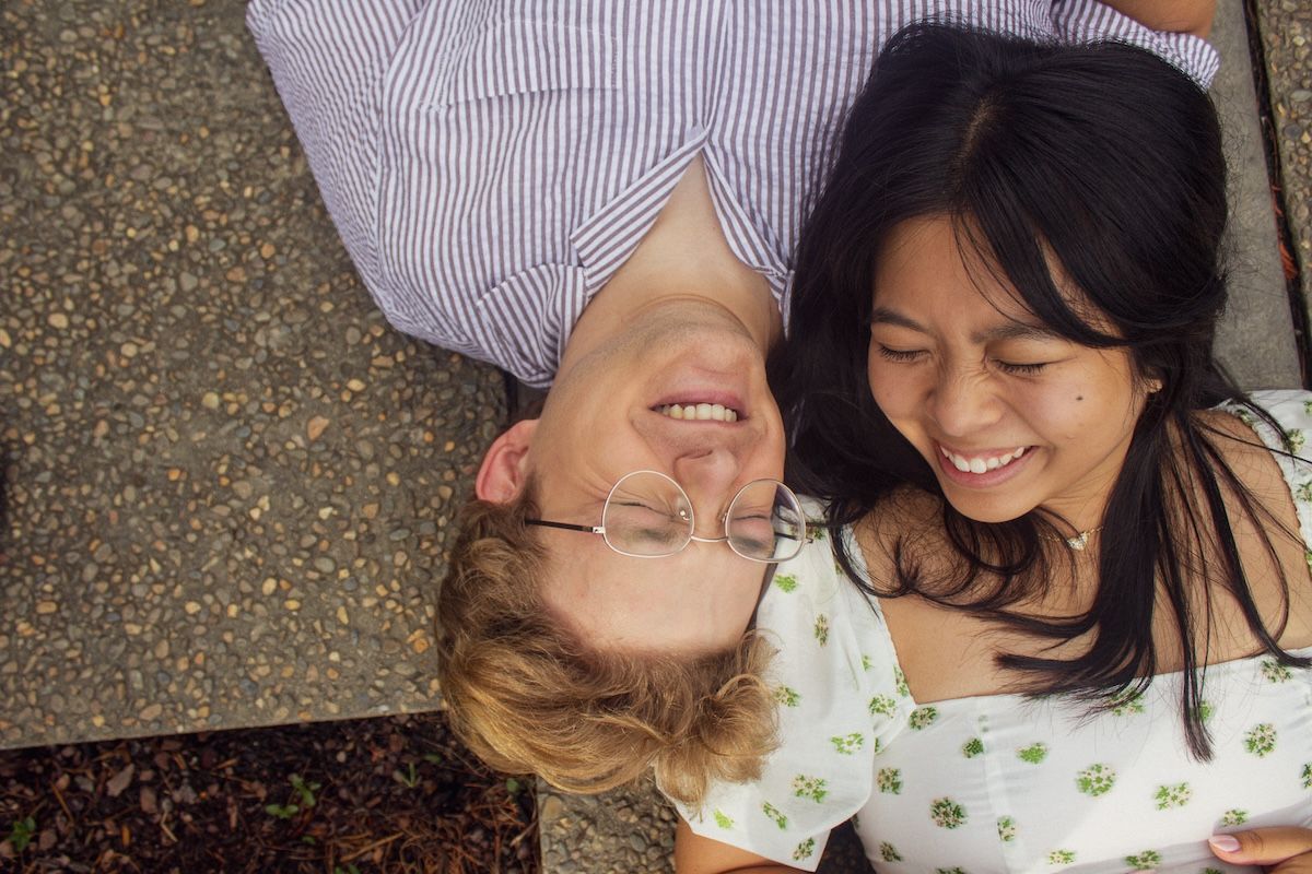 engaged couple laying with heads next to each other