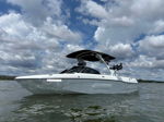Low-angle view Ryan's white Malibu wakeboard boat on water under cloudy sky photo 4