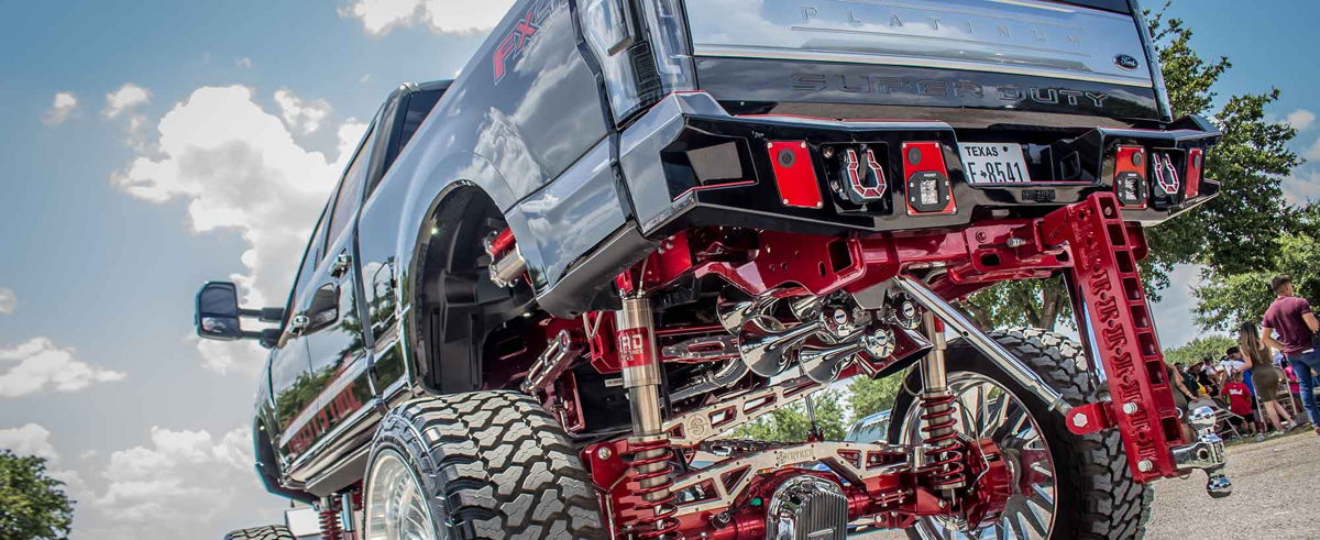 Lifted Super Duty with chrome train horns and red suspension undercarriage