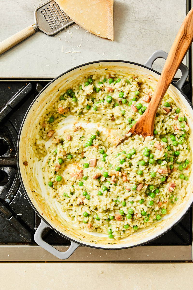 Risotto, pesto, peas and pancetta in a sauce pan