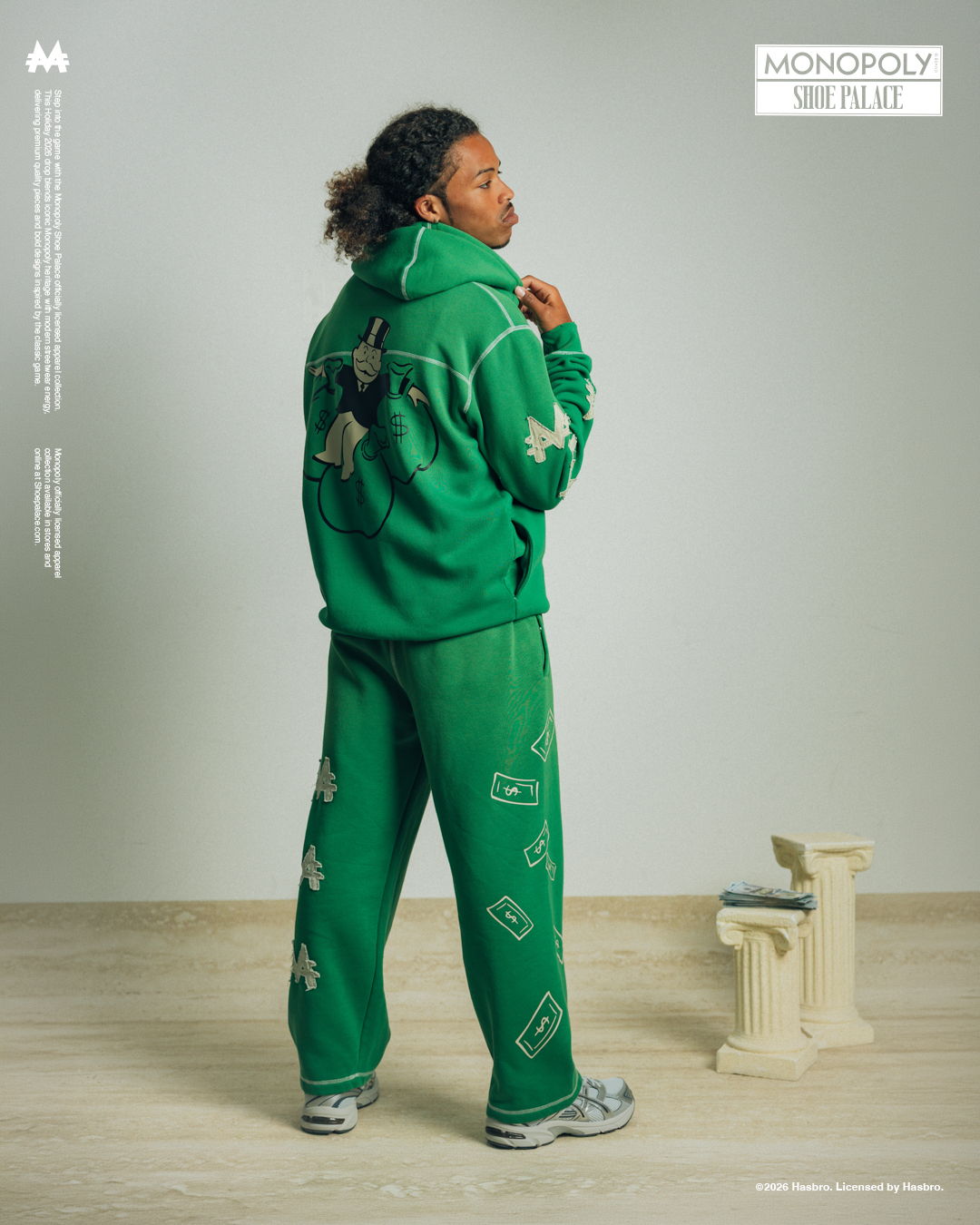 Person wearing a green tracksuit, facing away, standing on a light floor.