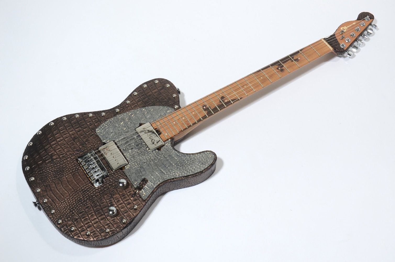A unique electric guitar with a wooden body and metal accents.
