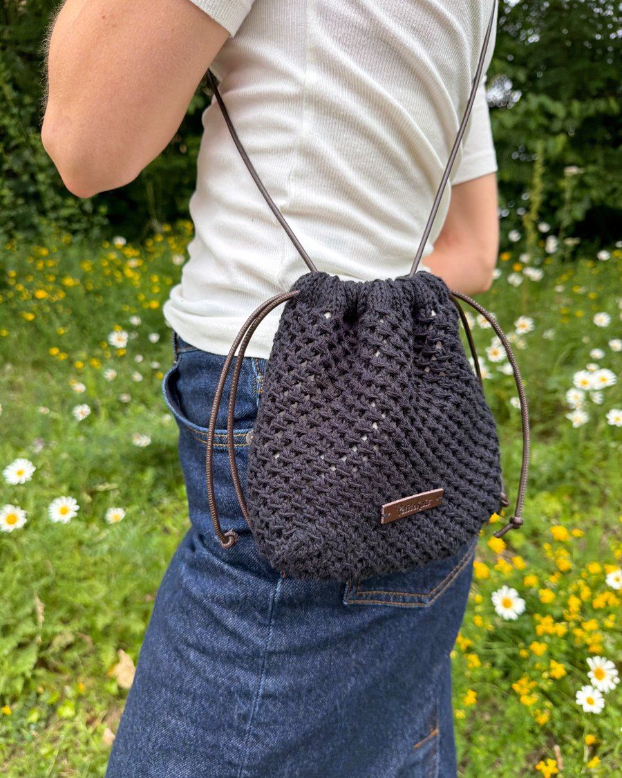 Kvinde i nederdel med sort Juno Satchel over skulderen