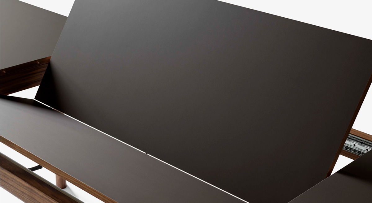 A long wooden dining table with minimalistic design and slender legs.
