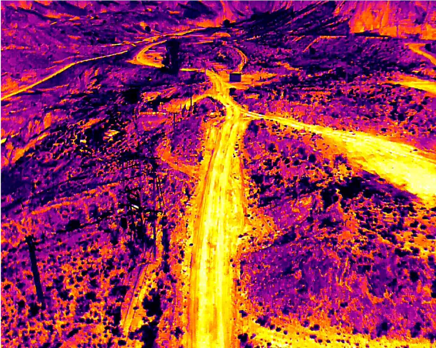 Thermal aerial view of mine roads and surrounding terrain showing contrasting surface temperatures