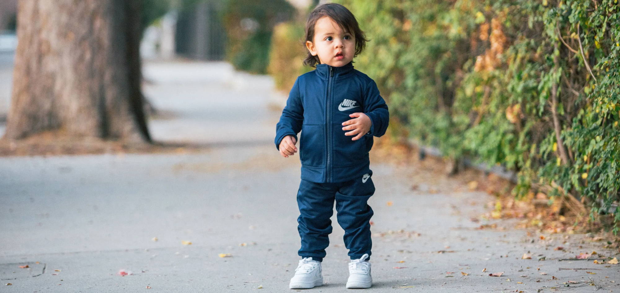 toddler boy wearing all nike walking on sidewalk 